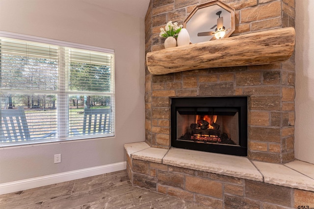 interior details with a ceiling fan, a fireplace, and baseboards