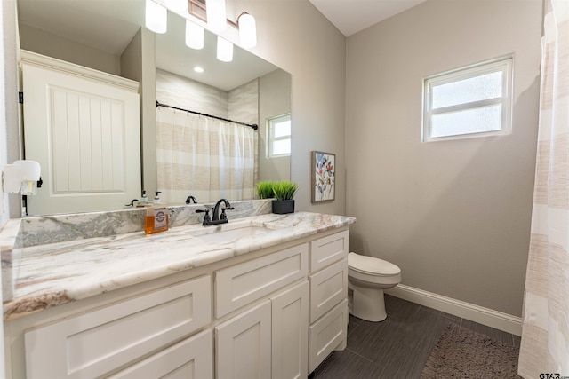 full bath with a shower with shower curtain, baseboards, vanity, and toilet