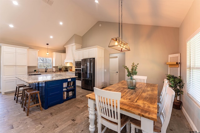 dining area featuring light wood finished floors, recessed lighting, visible vents, high vaulted ceiling, and baseboards