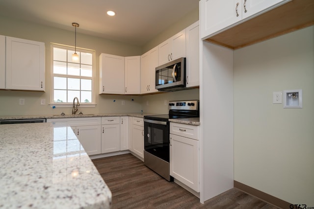 kitchen featuring white cabinets, stainless steel appliances, and pendant lighting