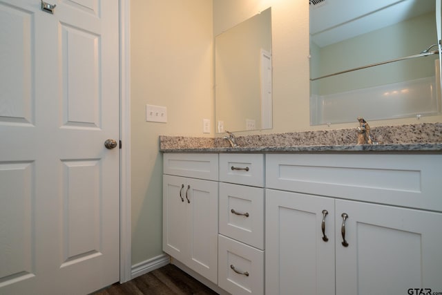 bathroom featuring walk in shower, vanity, and hardwood / wood-style flooring