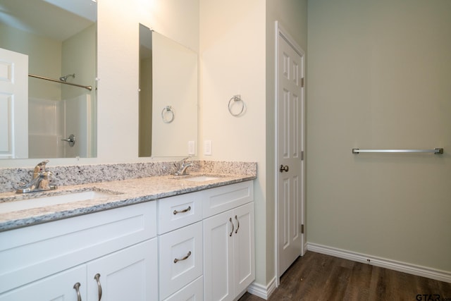 bathroom featuring walk in shower, vanity, and hardwood / wood-style flooring