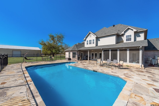 view of pool featuring a patio, a sunroom, and a yard