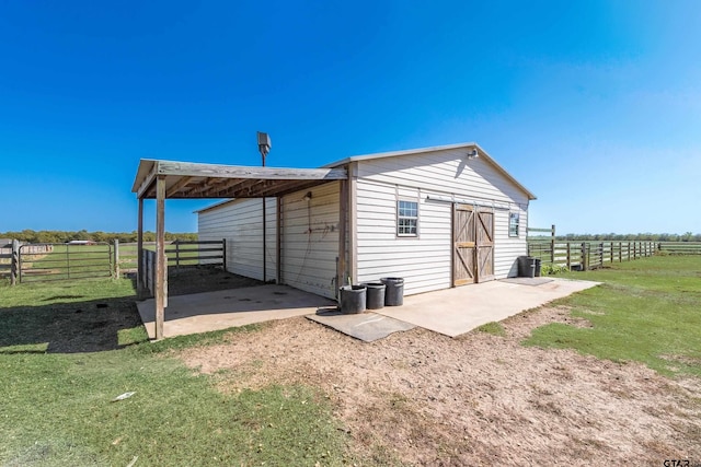 view of outdoor structure featuring a rural view and a yard