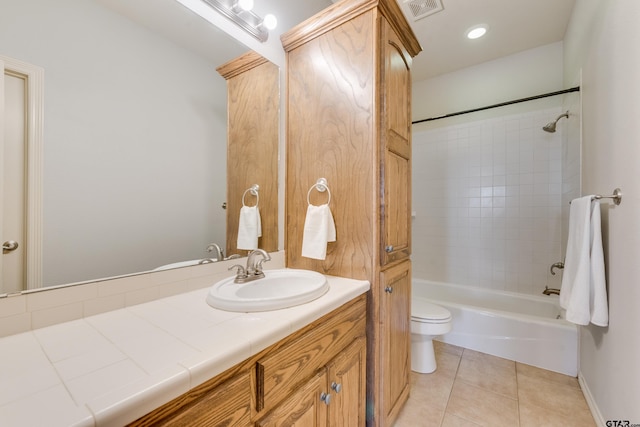 full bathroom featuring tile patterned flooring, vanity, tiled shower / bath combo, and toilet