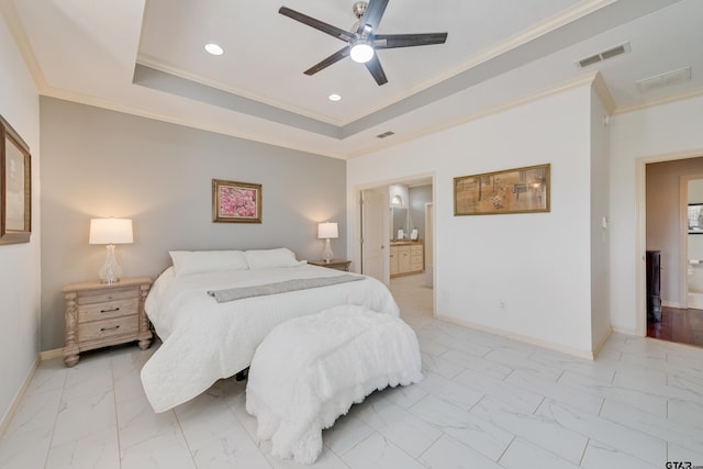 bedroom featuring ceiling fan, ensuite bath, a raised ceiling, and crown molding