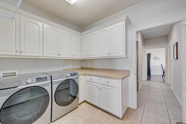 washroom featuring separate washer and dryer, cabinets, and light tile patterned floors