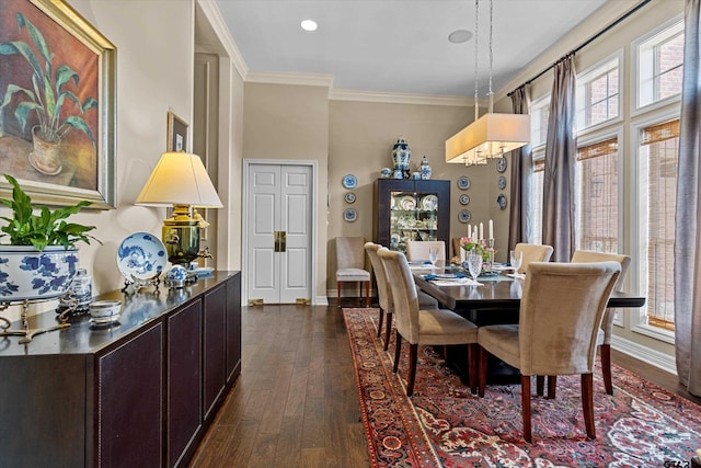 dining room with dark hardwood / wood-style floors, a healthy amount of sunlight, and ornamental molding