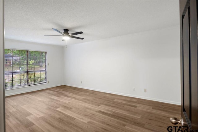 unfurnished room with ornamental molding, wood finished floors, baseboards, ceiling fan, and a textured ceiling