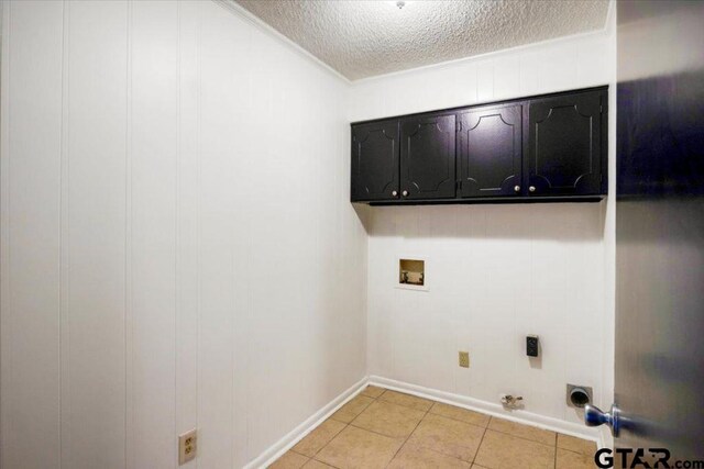 laundry room with light tile patterned flooring, a textured ceiling, cabinet space, washer hookup, and hookup for a gas dryer