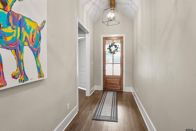 doorway featuring an inviting chandelier, lofted ceiling, and dark hardwood / wood-style floors