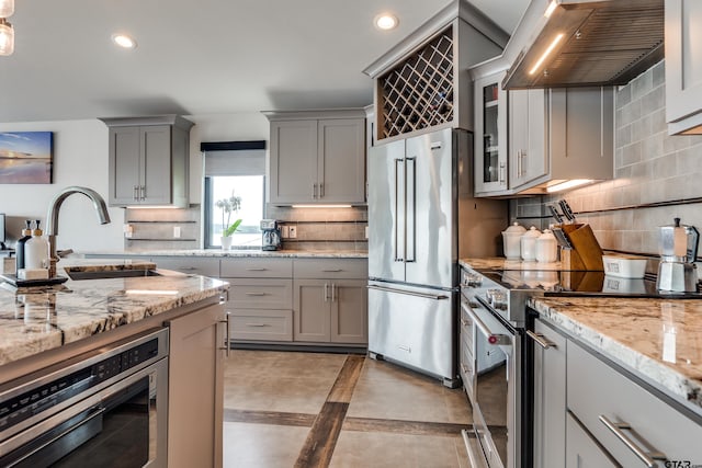 16822 Perry St, Tyler, TX 75707 - kitchen featuring gray cabinetry, stainless steel appliances, wall chimney range hood, decorative backsplash, and recessed lighting