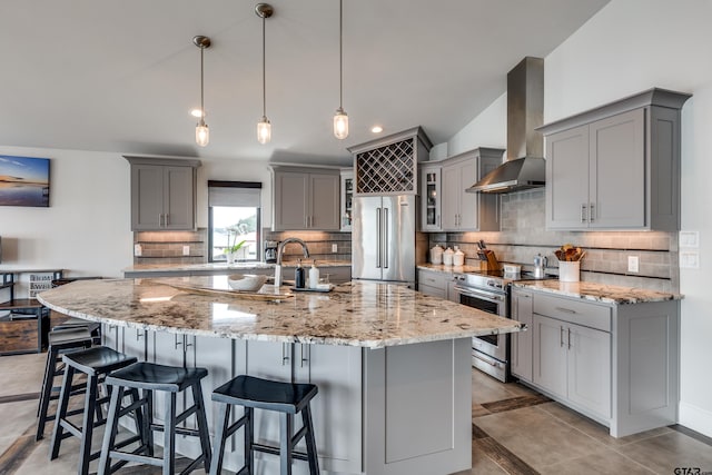 16822 Perry St, Tyler, TX 75707 - kitchen with gray cabinets, wall chimney range hood, stainless steel appliances, a kitchen breakfast bar, and recessed lighting