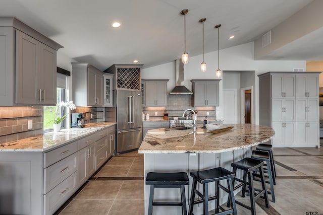 16822 Perry St, Tyler, TX 75707 - kitchen featuring gray cabinets, appliances with stainless steel finishes, a breakfast bar area, wall chimney range hood, and recessed lighting