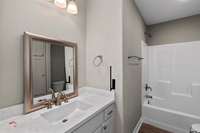 108 Benny St, Longview, TX 75604 - bathroom with toilet, vanity, washtub / shower combination, and wood finished floors