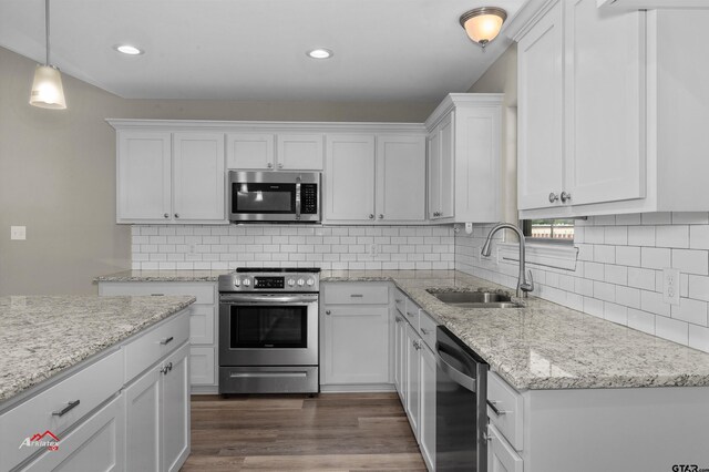 108 Benny St, Longview, TX 75604 - kitchen featuring appliances with stainless steel finishes, a sink, white cabinets, dark wood-type flooring, and tasteful backsplash