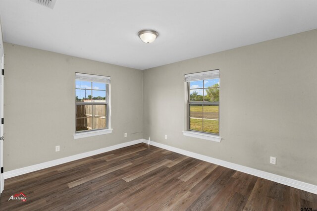 108 Benny St, Longview, TX 75604 - unfurnished room featuring healthy amount of natural light, dark wood finished floors, and baseboards