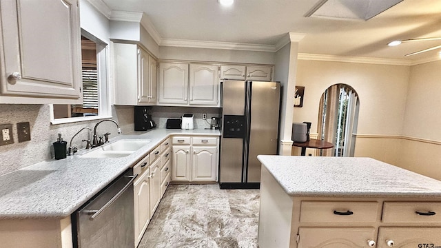 kitchen featuring tasteful backsplash, ornamental molding, appliances with stainless steel finishes, and sink