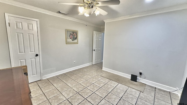 tiled spare room with ornamental molding and ceiling fan