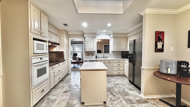 kitchen featuring sink, white appliances, backsplash, ornamental molding, and a kitchen island