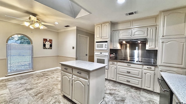 kitchen with white appliances, ornamental molding, a kitchen island, ceiling fan, and decorative backsplash