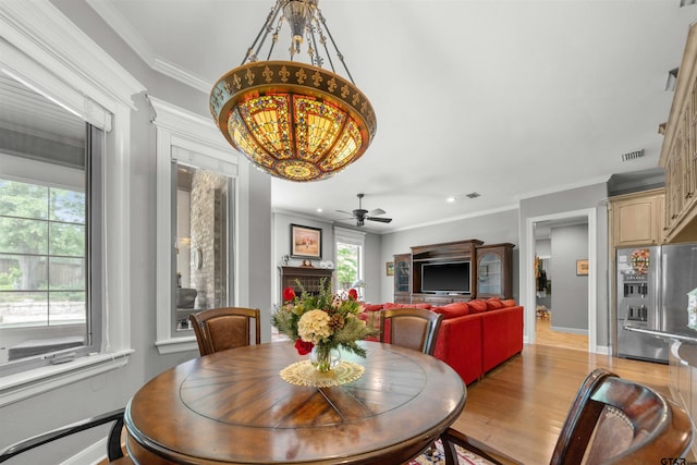 dining area with light hardwood / wood-style flooring, ceiling fan, and crown molding