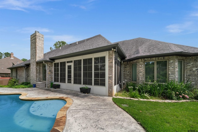 rear view of property with a patio, a sunroom, and a yard