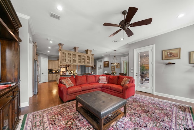 living room featuring ceiling fan, crown molding, and dark hardwood / wood-style flooring