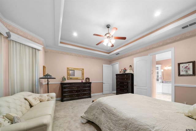 bedroom featuring crown molding, ensuite bath, a raised ceiling, light colored carpet, and ceiling fan