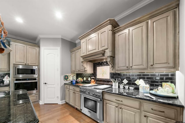 kitchen featuring dark stone counters, tasteful backsplash, appliances with stainless steel finishes, and light hardwood / wood-style floors