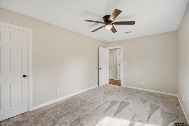 unfurnished room featuring carpet, visible vents, and baseboards