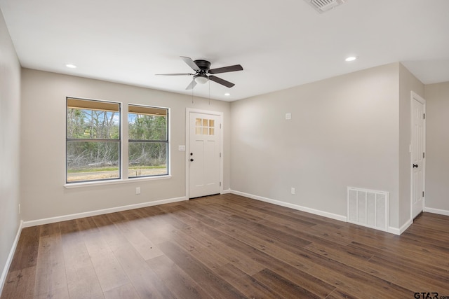 spare room featuring dark wood-style floors, recessed lighting, visible vents, and baseboards