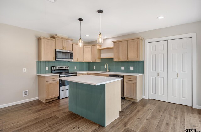 kitchen featuring stainless steel appliances, light countertops, light brown cabinetry, open shelves, and a sink