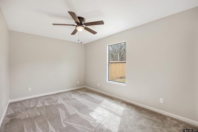 unfurnished room featuring light colored carpet, ceiling fan, and baseboards