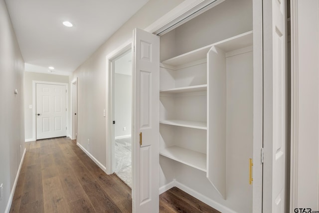 corridor featuring recessed lighting, dark wood finished floors, and baseboards