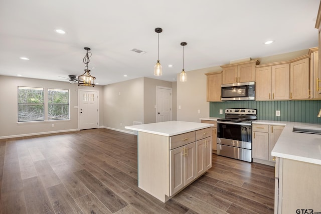 kitchen with dark wood-style floors, a center island, light countertops, appliances with stainless steel finishes, and open floor plan