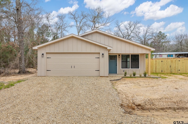 view of front of house with driveway, an attached garage, and fence