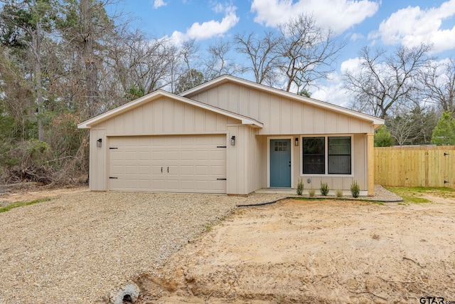 view of front of property featuring a garage, driveway, and fence