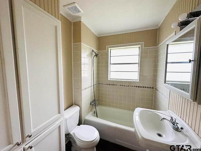 full bathroom with visible vents, toilet, tub / shower combination, a sink, and wallpapered walls