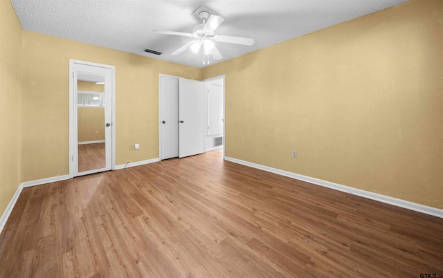 unfurnished bedroom with a textured ceiling, ceiling fan, and light hardwood / wood-style floors