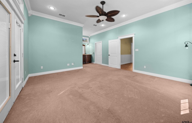 unfurnished bedroom featuring ceiling fan, ensuite bathroom, light colored carpet, and ornamental molding