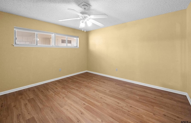 unfurnished room with ceiling fan, wood-type flooring, and a textured ceiling