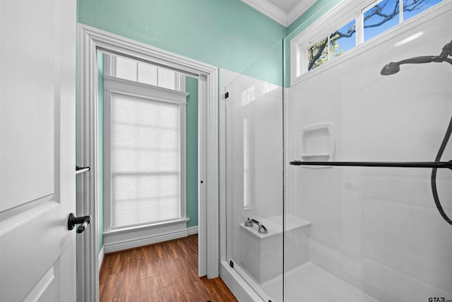 bathroom with crown molding, wood-type flooring, and a shower with door