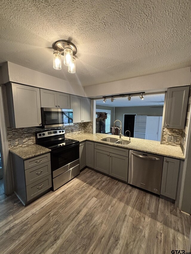 606 Glazner St, Hawkins, TX 75765 - kitchen featuring stainless steel appliances, gray cabinets, a sink, dark wood finished floors, and tasteful backsplash