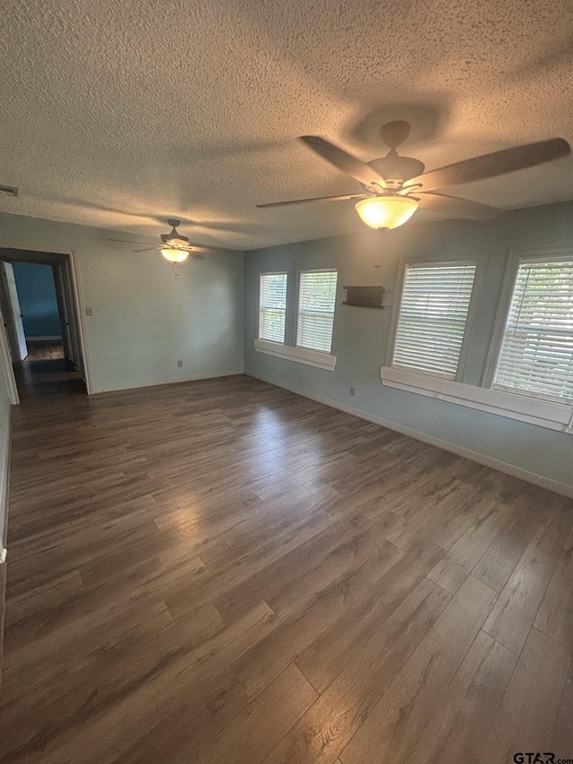 606 Glazner St, Hawkins, TX 75765 - empty room with a ceiling fan, a textured ceiling, dark wood-type flooring, plenty of natural light, and baseboards