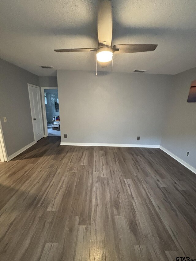 606 Glazner St, Hawkins, TX 75765 - spare room featuring ceiling fan, dark wood-style floors, baseboards, and a textured ceiling