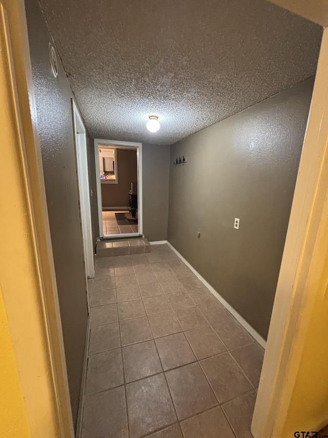 606 Glazner St, Hawkins, TX 75765 - corridor with dark tile patterned floors, baseboards, and a textured ceiling