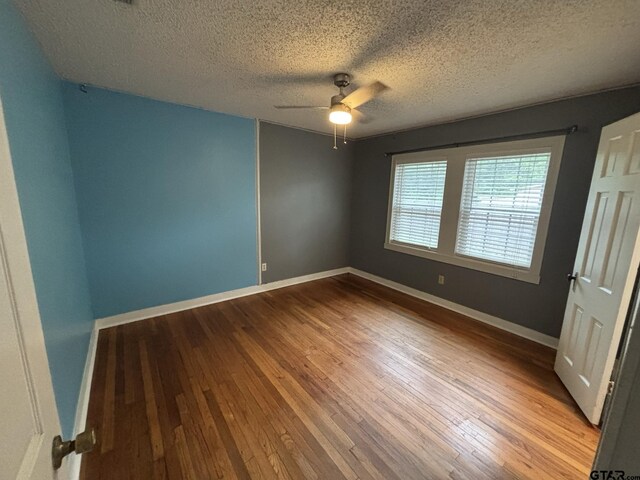 606 Glazner St, Hawkins, TX 75765 - empty room with ceiling fan, a textured ceiling, wood-type flooring, and baseboards
