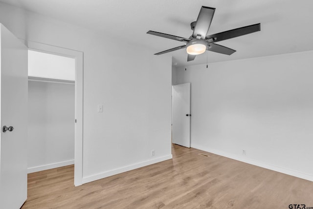 441 N Hill, Tyler, TX 75706 - unfurnished bedroom featuring a spacious closet, light wood-type flooring, a closet, and a ceiling fan