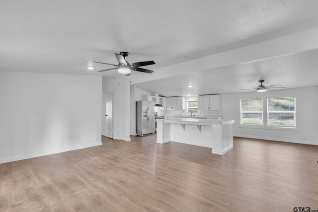 441 N Hill, Tyler, TX 75706 - unfurnished living room with ceiling fan and light wood-style floors